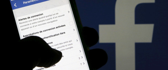 A man reads parameters of security on his phone in front of a displayed Facebook logo in Bordeaux, southwestern France, March 10, 2016. REUTERS/Regis Duvignau/Illustration