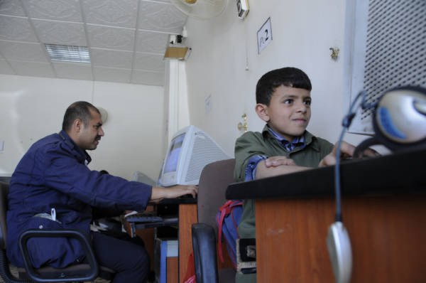 Patrons use computers in an internet cafe that was assisted by a microloan from the Social Welfare Fund.